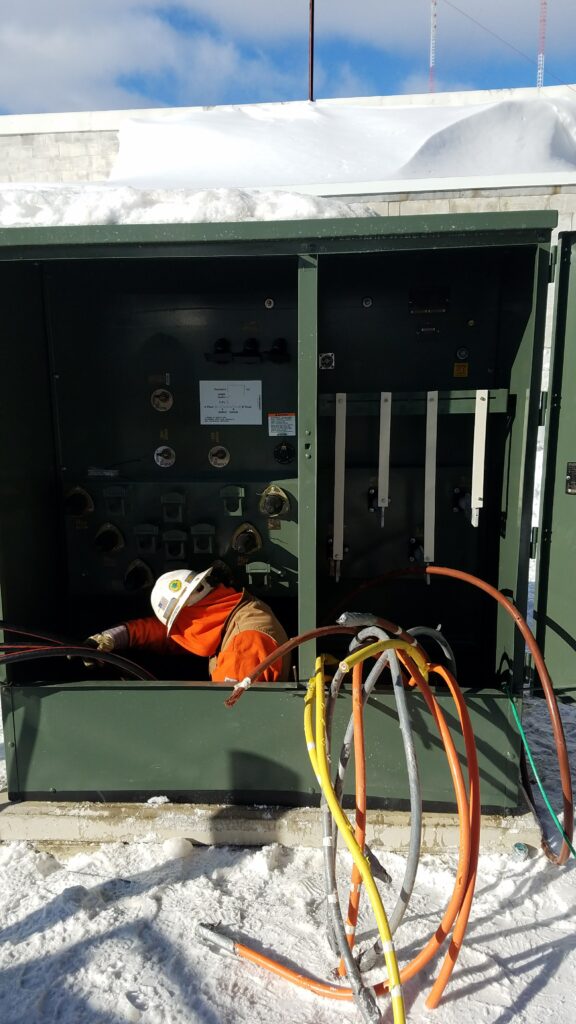 Licensed electrician wiring a meter pedestal and underground utility service feed installation in Connecticut and Massachusetts.